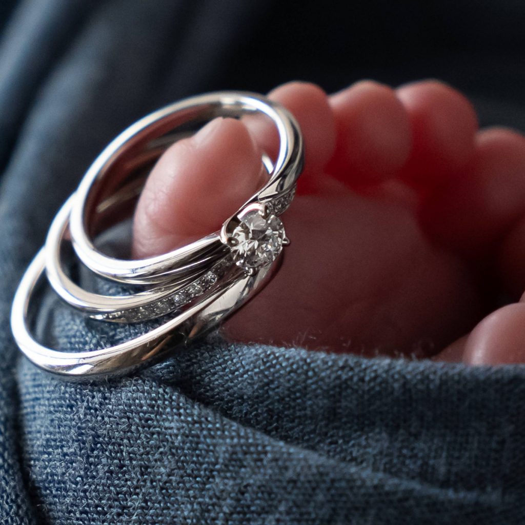 赤ちゃんの足元に指輪を添えた記念写真