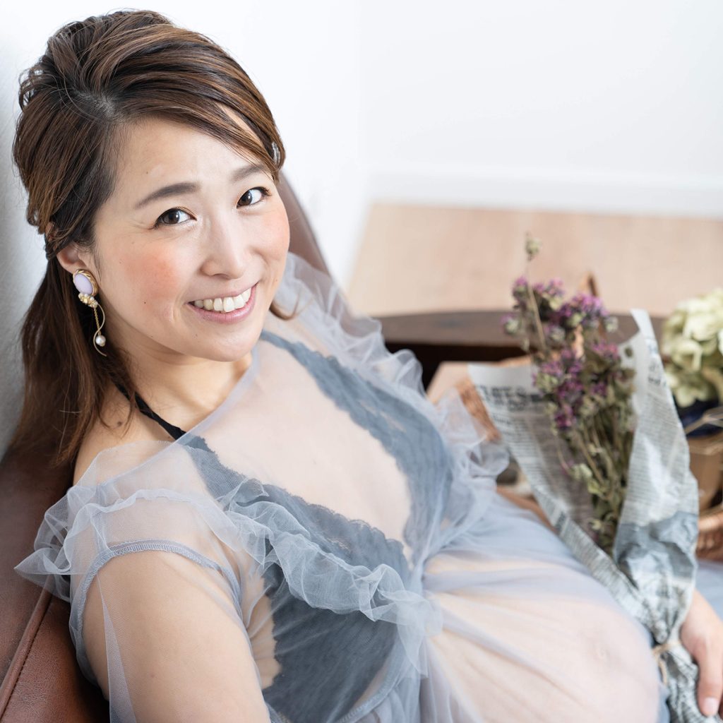 自然光に包まれた室内で微笑む妊婦さんの記念写真