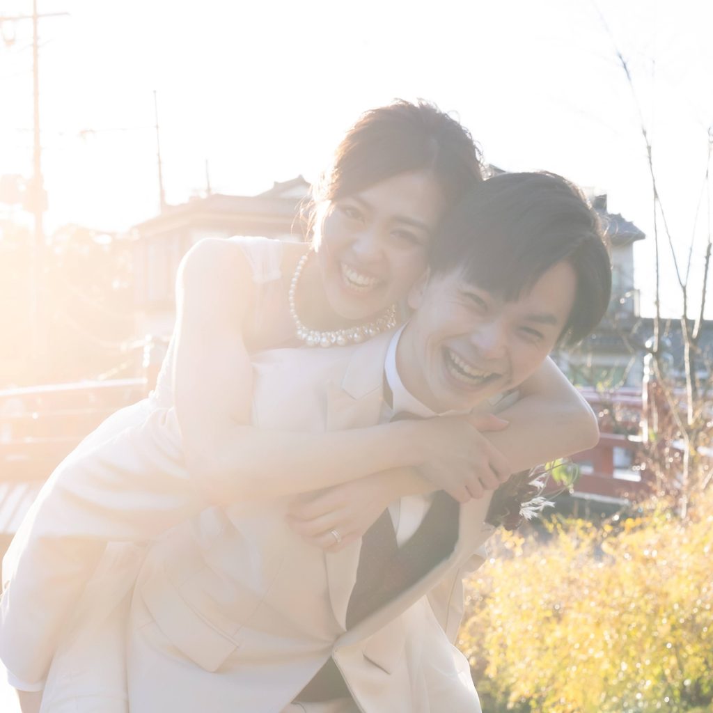 夕陽に包まれながら笑い合う新郎新婦の自然な記念写真