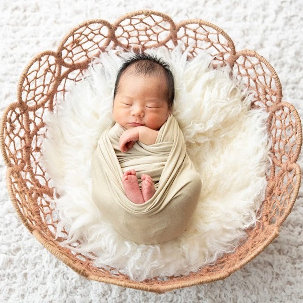 かごの中で眠る新生児のニューボーンフォト