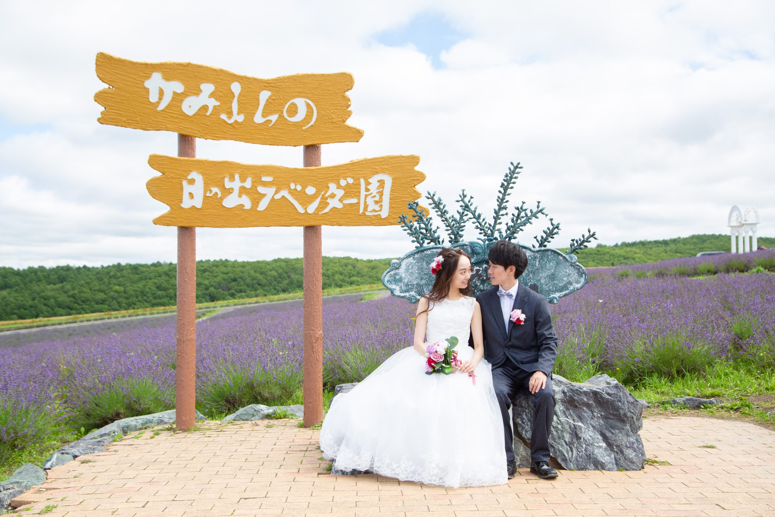 日の出ラベンダー園で互いを見つめ合う新郎新婦の写真