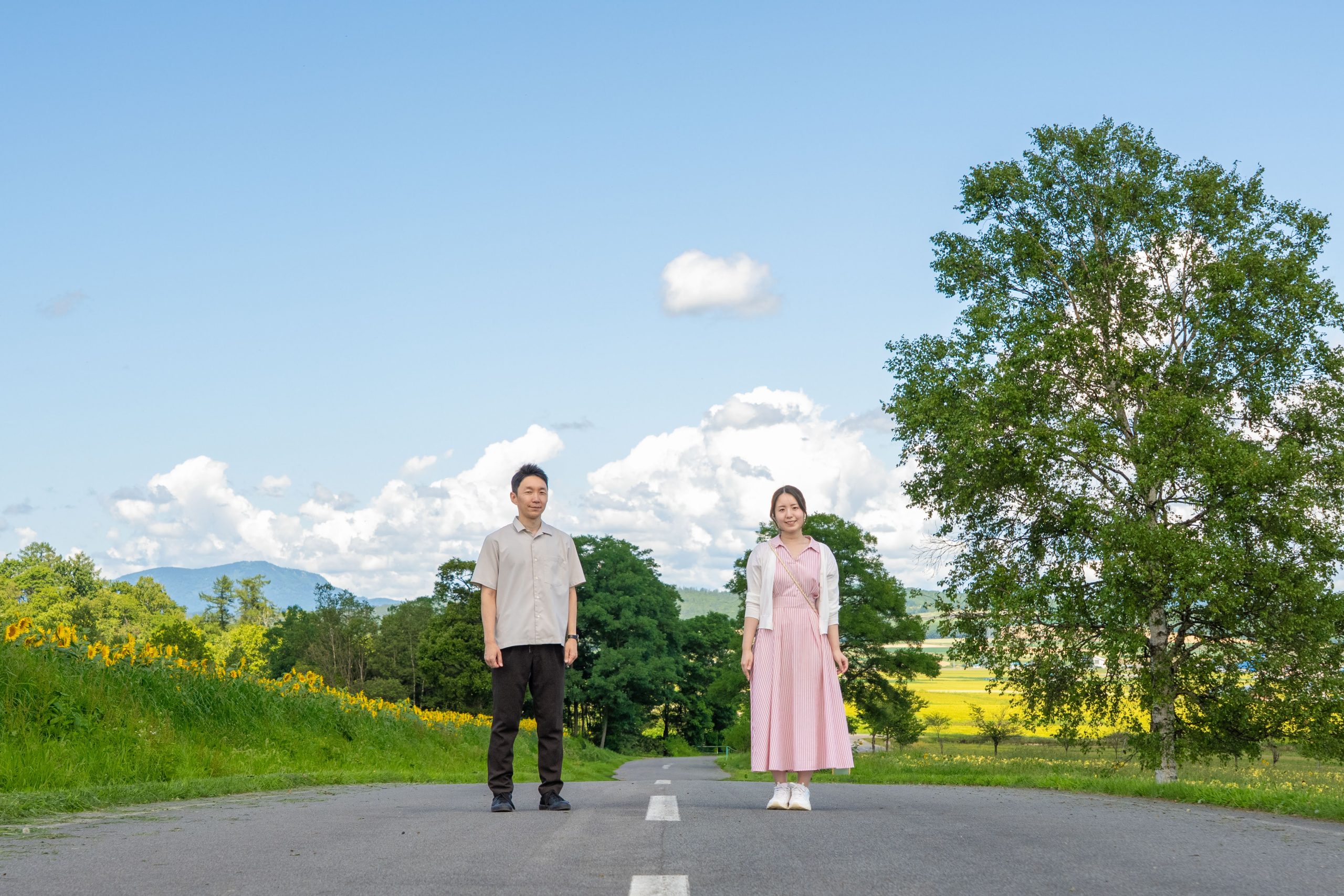 北海道の自然に囲まれた道で佇むカップルのロケーション撮影