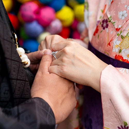 Close-up of a couple in traditional Kimono showing a sparkling engagement ring for a surprise proposal shoot.