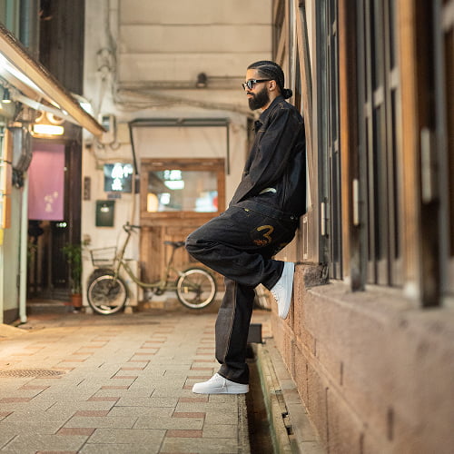 A stylish solo portrait of a male traveler exploring the streets of Japan.
